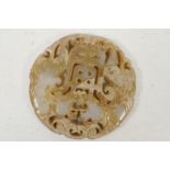 A Chinese carved jade roundel carved with exotic beasts and symbols, 2½" diameter