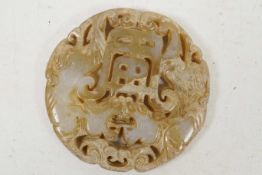 A Chinese carved jade roundel carved with exotic beasts and symbols, 2½" diameter