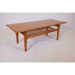 A Danish teak two tier coffee table by Trioh Co, with solid top and openwork undertier on four