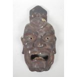 A Japanese carved and lacquered wood Oni mask, 15" long