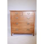 An early C20th oak chest of two over three drawers, with brass handles, raised on carved stile