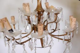 A brass twelve light two tier chandelier with glass shades, 22" diameter, 15" drop