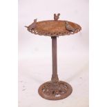A Victorian cast iron bird bath with a pierced rim surmounted by three birds, 31" high x 20"