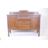 A 1930s oak breakfront sideboard with two cupboards flanking three drawers, 55" x 19" x 39"