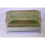 An early C20th tub shaped two seater settee with shaped ends and button back upholstery, 52" wide,