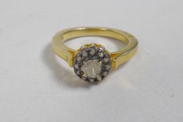 A silver gilt ring set with an Indian uncut diamond encircled by smaller diamonds, approximate