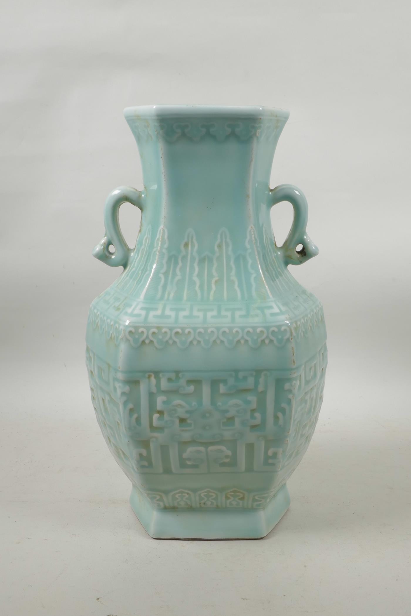 A Chinese celadon glazed porcelain two handled vase with archaic underglaze decoration, seal mark to