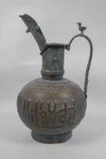 An Islamic copper ewer with repousse and silver inlaid calligraphy decoration, 13" high
