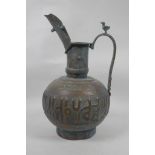 An Islamic copper ewer with repousse and silver inlaid calligraphy decoration, 13" high