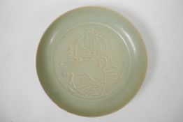 A Chinese Song style celadon glazed dish with incised figural decoration, character inscription to