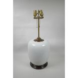 An Oriental white ground porcelain lamp with brass fittings on a hardwood base, 23½" high
