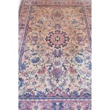 An amber ground oriental carpet with floral decoration, 72" x 104"