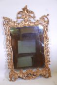 A carved and pierced giltwood framed wall mirror with antiqued glass, 50" x 30"