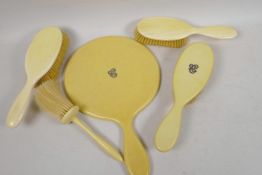 A pair of 1920s ivory backed hair brushes together with a similar clothes brush, and an ivorine