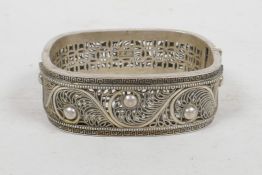 A Chinese white metal filigree bangle, impressed 2 character mark to interior, 2" x 2½"