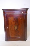 A Georgian mahogany hanging corner cupboard with inlaid decoration depicting Old Father Time, 37"