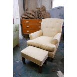 A contemporary armchair with buttoned back upholstery and matching footstool