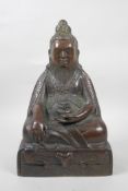 A Tibetan bronze of a bearded deity/figure seated in meditation, 12" high