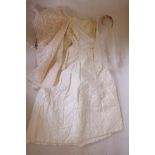 An embroidered cream satin wedding dress, and two veils