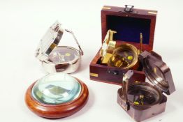 A hardwood cased paperweight compass, 4" diameter, together with three brass cased sighting