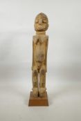 An early C20th carved wood fertility figure of a female nude, 20" high