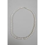 A freshwater pearl necklace set with three cubic zirconium encrusted feature beads, 17" long