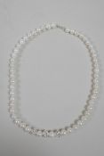 A freshwater pearl necklace set with three cubic zirconium encrusted feature beads, 17" long