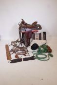 A tooled leather Western saddle by Bona Allen with leather stirrups, fleece lined, comes with
