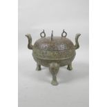 A Chinese archaic bronze censer and cover on tripod feet with two handles, the cover with all over