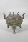 A Chinese archaic bronze censer and cover on tripod feet with two handles, the cover with all over
