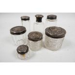 Seven glass dressing table/vanity jars with hallmarked silver tops (silver weight 48 grams)