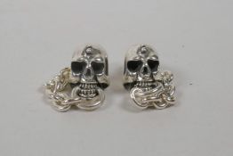 A pair of silver skull earrings