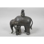 A Chinese white metal figure of an elephant with two children, the elephant having paw feet, 7" high