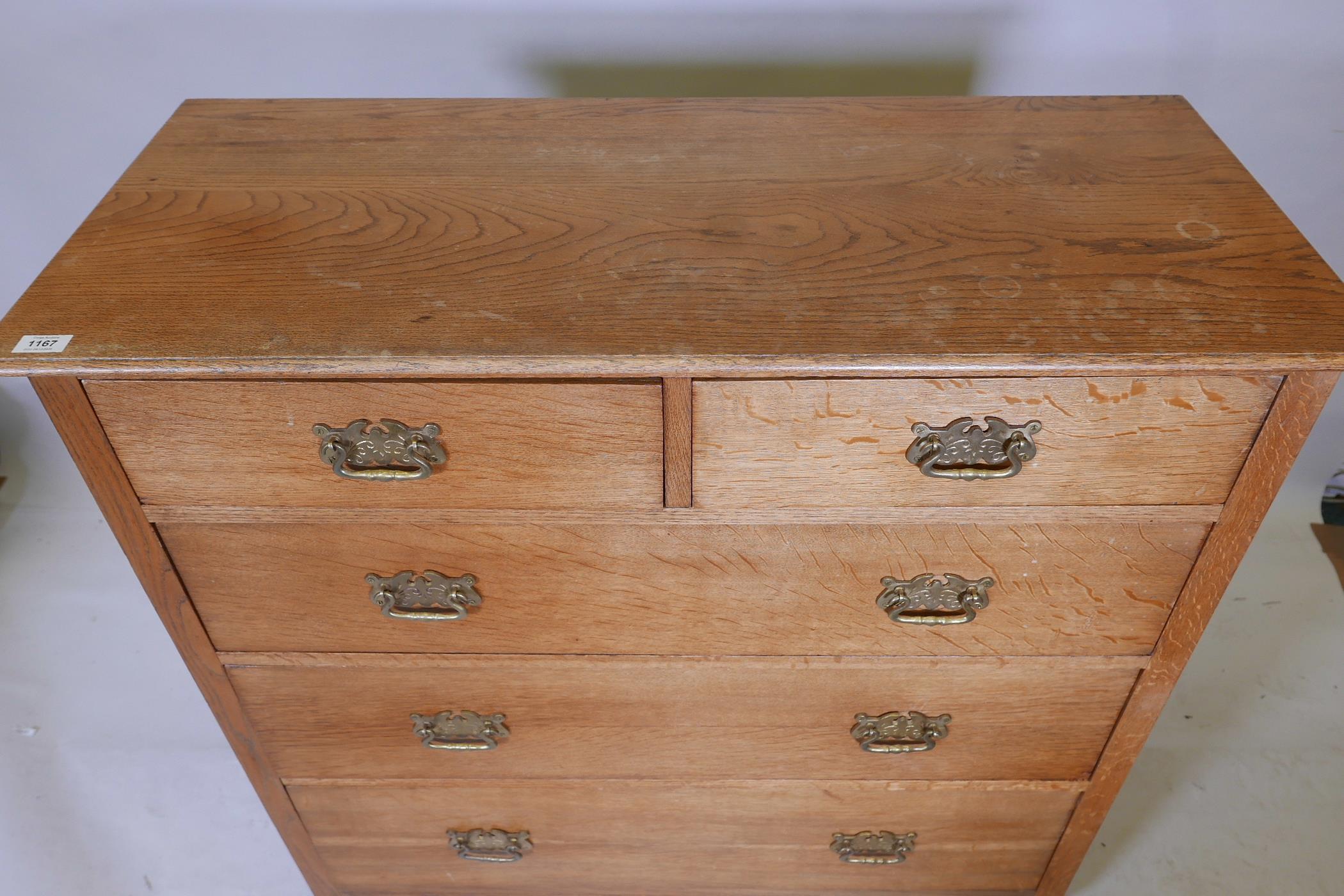 An early C20th oak chest of two over three drawers, with brass handles, raised on carved stile - Image 3 of 3