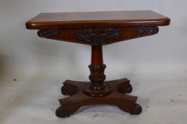 A William IV mahogany card table on a carved and turned column, platform base and four scrolled