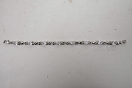 A silver and cubic zirconium set line bracelet, 7" long