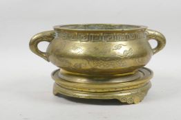 A Chinese bronze censer and stand, the handles in the form of fish, and all over engraved decoration