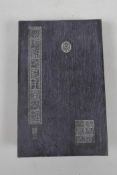 A Chinese hardwood and silk bound book containing white jade tablets with engraved and gilt