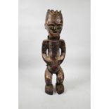 An African carved wood and plastered tribal figure with shell set eyes, 20" high, possibly from