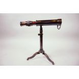 A small table top brass telescope, 9" long, on tripod stand