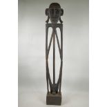 An African carved wood slender squatting figure, 35½" high