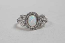 A silver, cubic zirconium and opalite panelled ring, approximate size 'P'