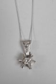 An 18ct white gold, star shaped and diamond set pendant necklace