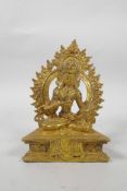 A Tibetan gilt bronze of Buddha, seated on a throne and holding a vajra, 7" high