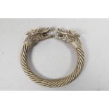 A Chinese white metal rope twist bangle with dragon head decoration to ends, 3½" diameter