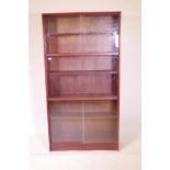 A Gibbs, mid C20th mahogany bookcase with sliding glass doors, 36" x 11" x 69"