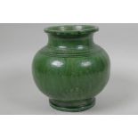 An Asian green glazed earthenware jar with engraved floral decoration, 6" high
