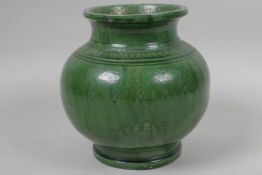 An Asian green glazed earthenware jar with engraved floral decoration, 6" high