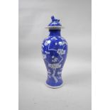 A C19th Chinese blue and white porcelain jar and cover with prunus blossom decoration on a cracked