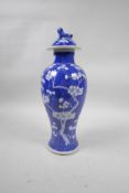 A C19th Chinese blue and white porcelain jar and cover with prunus blossom decoration on a cracked